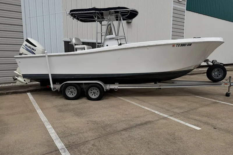 The Image of 1990 Mako 241 Center Console boat on trailer, parked outdoors. - 1