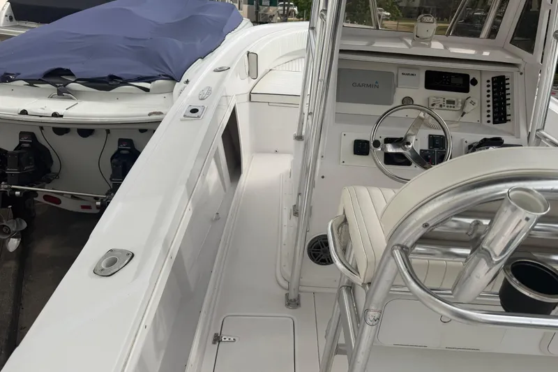 Slide: The Image of 1990 Mako 241 Center Console boat interior with steering wheel and navigation equipment. - 12