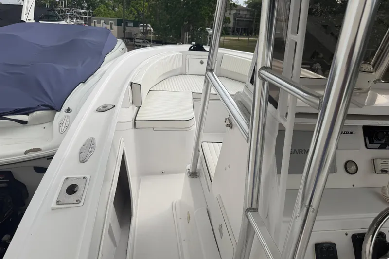 Slide: The Image of 1990 Mako 241 Center Console boat interior with white seating and stainless steel railings. - 13