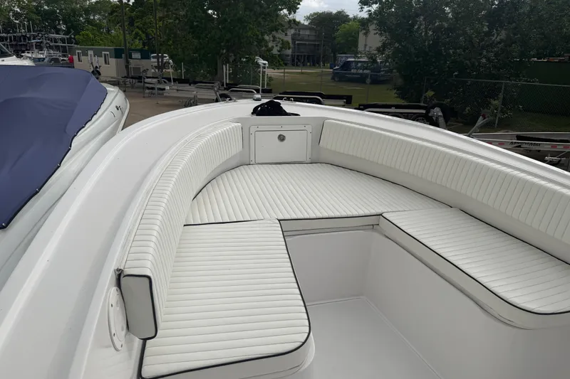 Slide: The Image of 1990 Mako 241 Center Console boat with white cushioned seating, docked outdoors. - 16