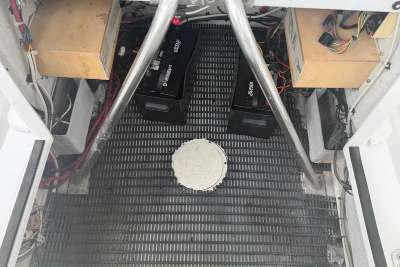 Slide: The Image of Interior view of a 1990 Mako 241 Center Console boat showing wiring and battery setup. - 17