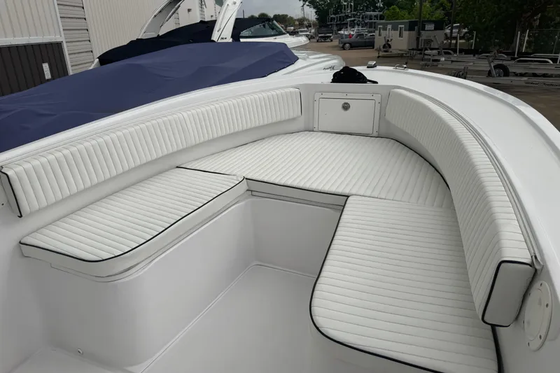 Slide: The Image of 1990 Mako 241 Center Console boat with white cushioned seating and storage compartment. - 19