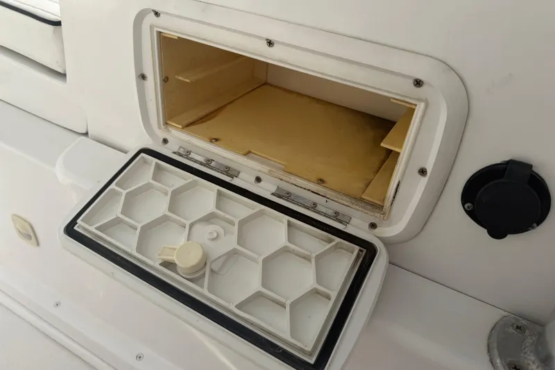 Slide: The Image of Open storage compartment on a 1990 Mako 241 Center Console boat. - 24