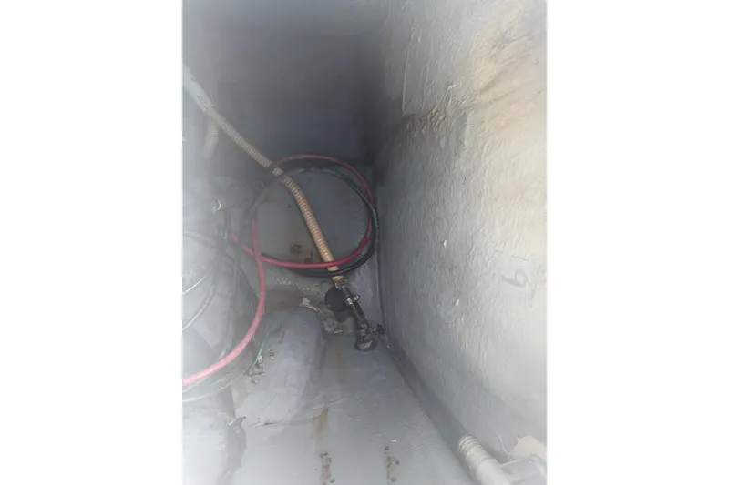 Slide: The Image of Interior view of a 1990 Mako 241 Center Console boat showing wiring and hoses. - 26