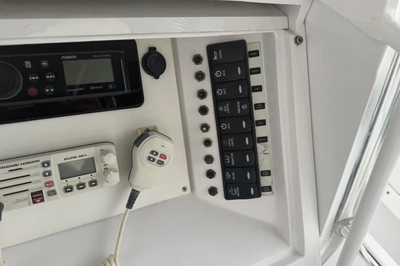 Slide: The Image of Control panel of a 1990 Mako 241 Center Console boat with radio and switches. - 29