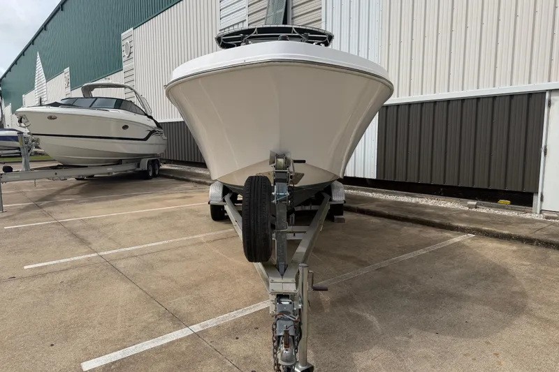 Slide: The Image of 1990 Mako 241 Center Console boat on trailer, parked outdoors near a building. - 3
