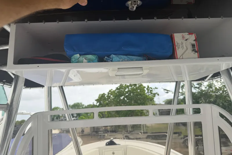 Slide: The Image of Storage compartment on a 1990 Mako 241 Center Console boat with various items inside. - 30