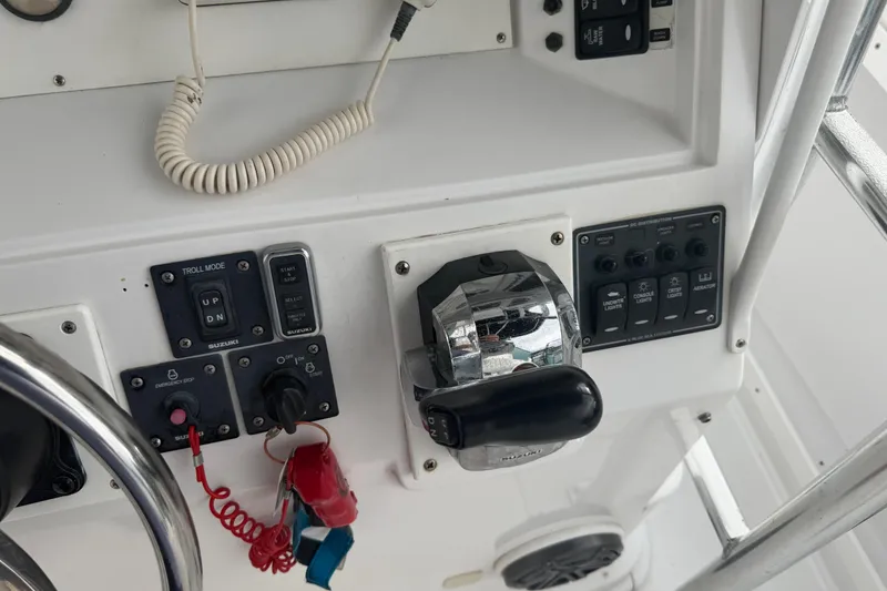 Slide: The Image of Control panel of a 1990 Mako 241 Center Console boat with various switches and throttle. - 32