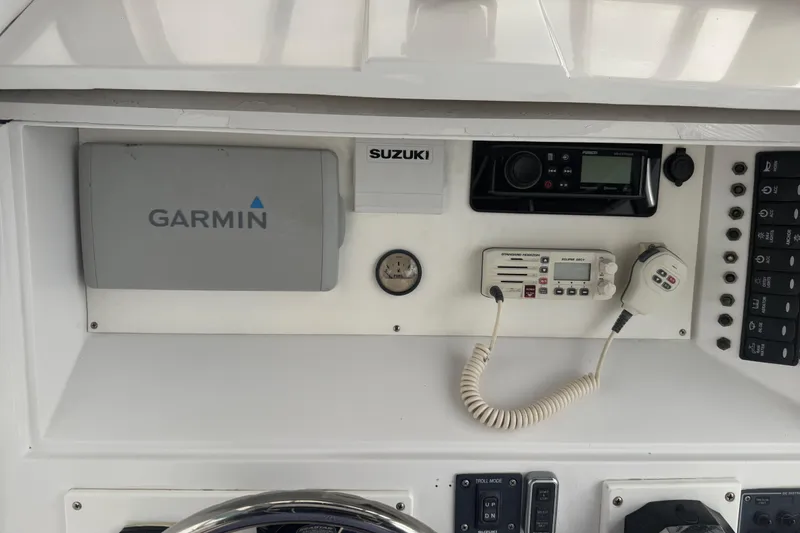 Slide: The Image of 1990 Mako 241 Center Console dashboard with Garmin, Suzuki, and Standard Horizon equipment. - 33