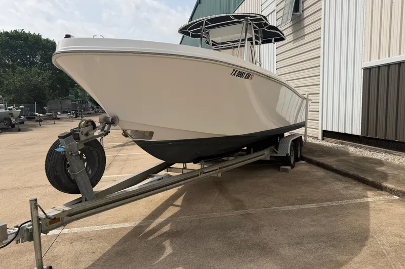 Slide: The Image of 1990 Mako 241 Center Console boat on trailer, parked beside a building. - 4