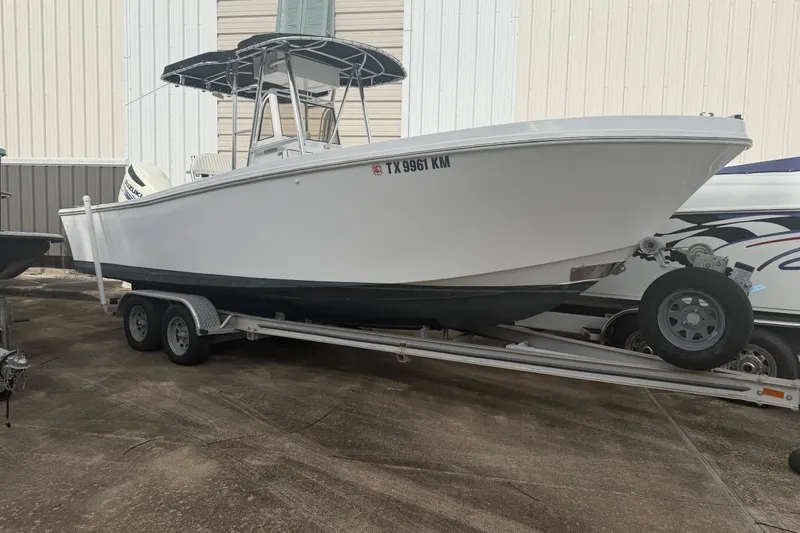 Slide: The Image of 1990 Mako 241 Center Console boat on trailer, parked outdoors. - 5