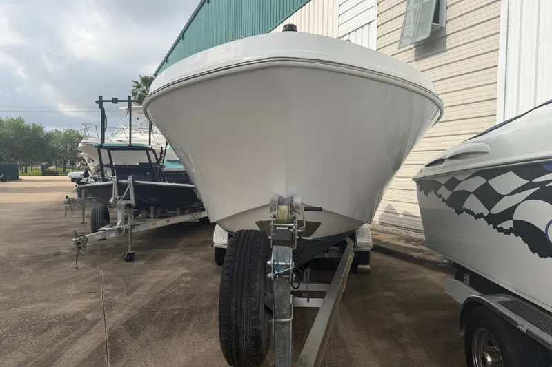 Slide: The Image of 1990 Mako 241 Center Console boat on trailer, parked outdoors near a building. - 6