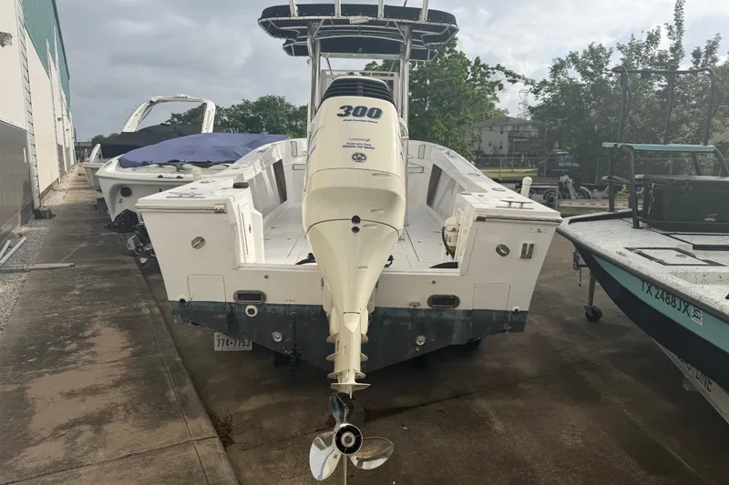 Slide: The Image of 1990 Mako 241 Center Console boat with powerful outboard motor, parked outdoors. - 7