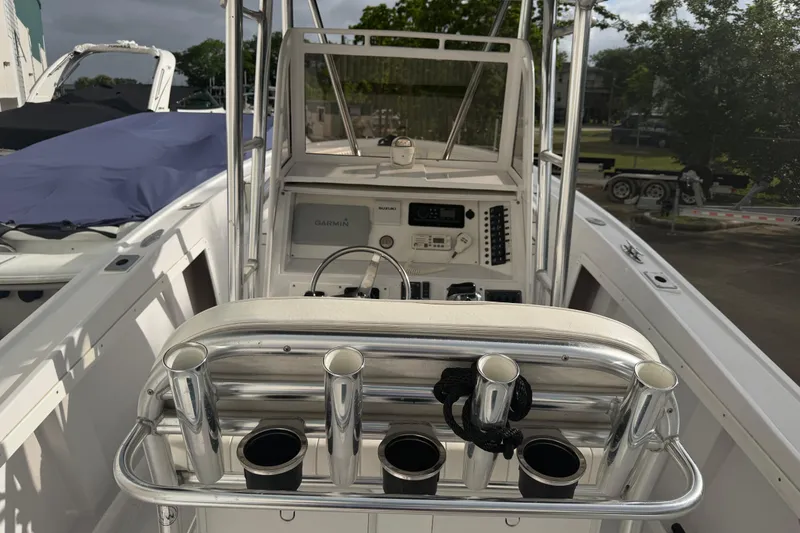 Slide: The Image of 1990 Mako 241 Center Console boat interior with steering and rod holders. - 8