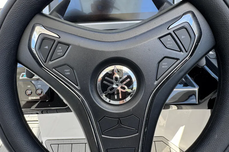 Slide: The Image of Steering wheel of 2026 Yamaha Boats 275SD with control buttons and logo. - 23