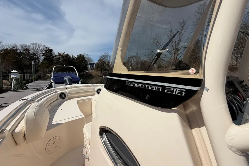 Slide: The Image of 2026 Grady-White Fisherman 216 boat docked, showcasing sleek design and spacious seating. - 15