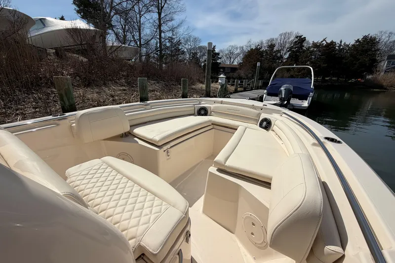 Slide: The Image of 2026 Grady-White Fisherman 216 boat interior with cushioned seating and docked in a serene setting. - 16