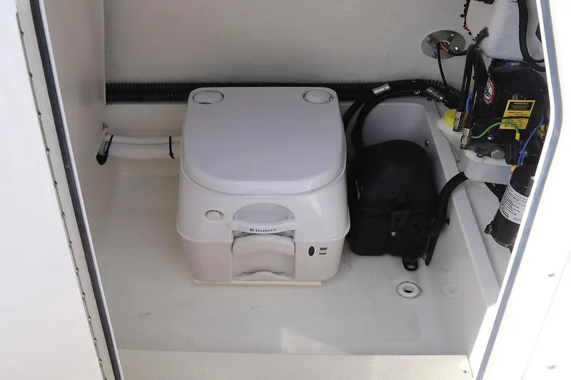 Slide: The Image of Manufacturer Provided Image: 2025 Sea Born FX25 Bay boat interior with compact marine toilet and equipment. - 8