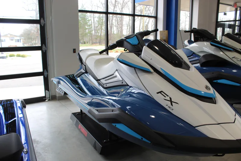 The Image of 2026 Yamaha WaveRunner FX HO jet ski in showroom, featuring sleek blue and white design. - 0
