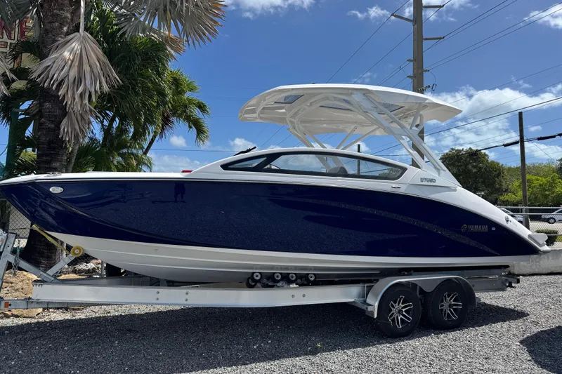 The Image of 2026 Yamaha Boats 275SD on trailer, sleek design, blue and white color scheme. - 0