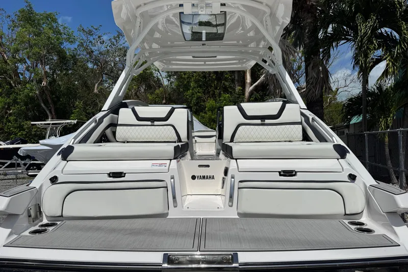 Slide: The Image of 2026 Yamaha Boats 275SD with luxurious seating and sleek design, docked outdoors. - 2