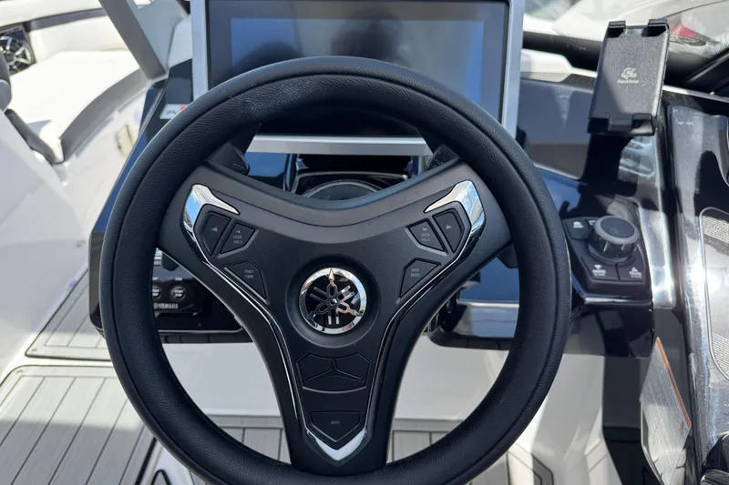 Slide: The Image of Steering wheel and dashboard of 2026 Yamaha Boats 275SD, featuring modern controls and display. - 22