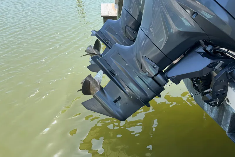 Slide: The Image of Twin outboard motors on a 2004 Grady-White Advance 257 boat, docked in water. - 10