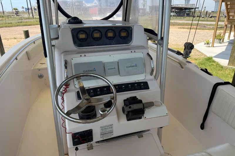 Slide: The Image of 2004 Grady-White Advance 257 boat dashboard with Garmin navigation system and steering wheel. - 12