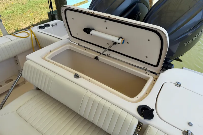 Slide: The Image of 2004 Grady-White Advance 257 boat with open storage compartment and Yamaha engines. - 15