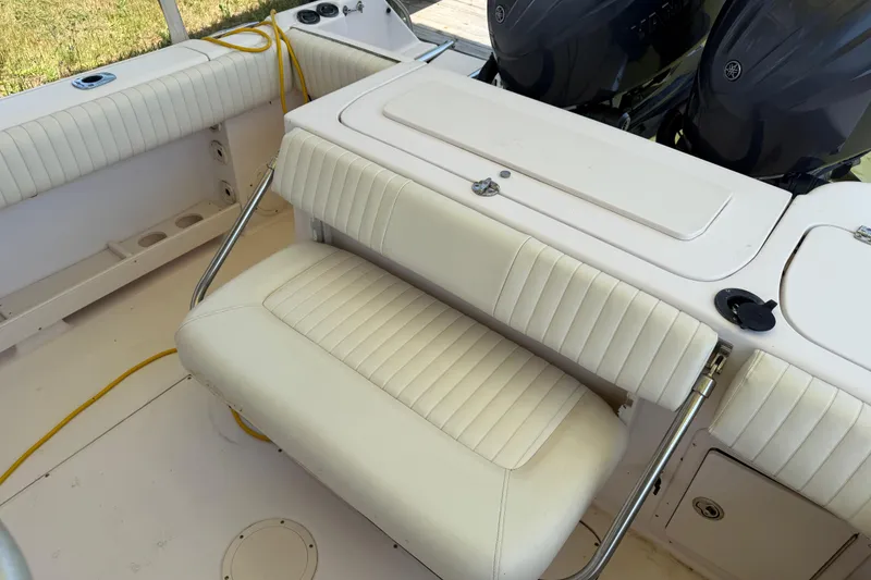 Slide: The Image of 2004 Grady-White Advance 257 boat interior with cushioned seating and dual engines. - 16
