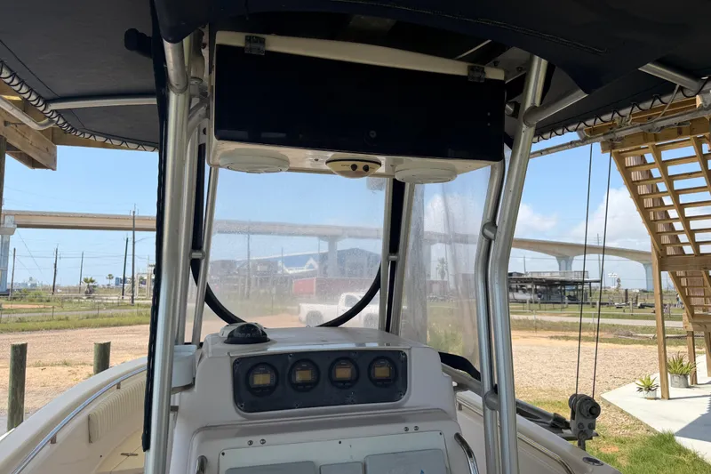 Slide: The Image of 2004 Grady-White Advance 257 boat console with gauges, under a canopy, near a bridge. - 17