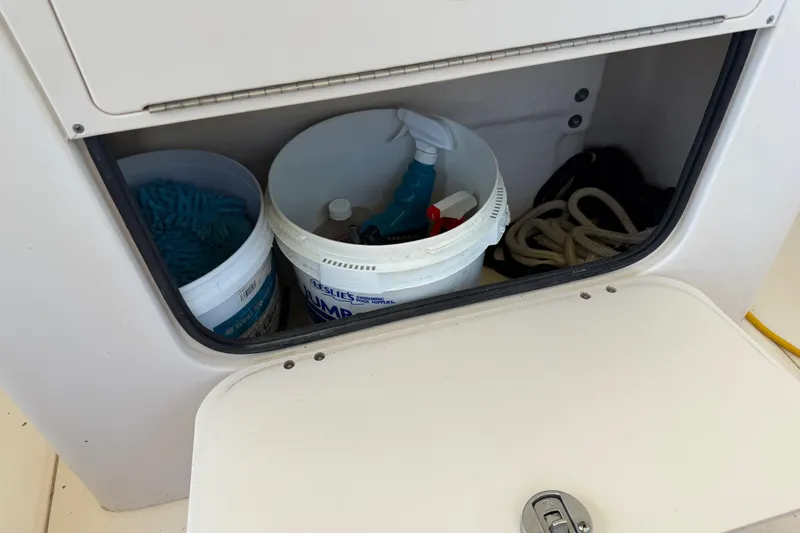 Slide: The Image of Storage compartment on a 2004 Grady-White Advance 257 boat with cleaning supplies and rope. - 20
