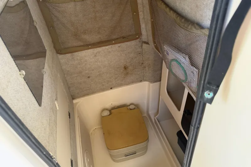 Slide: The Image of 2004 Grady-White Advance 257 boat interior with portable toilet and storage compartments. - 24