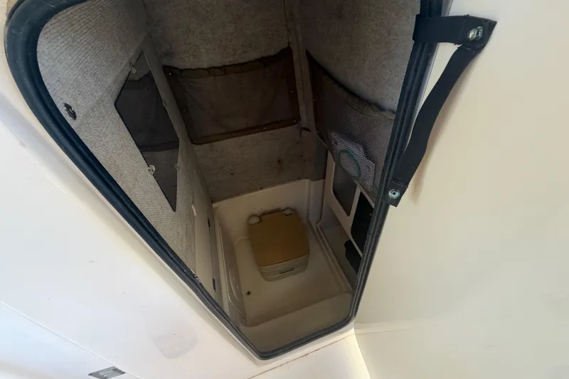 Slide: The Image of 2004 Grady-White Advance 257 boat interior with storage compartment and portable toilet. - 25