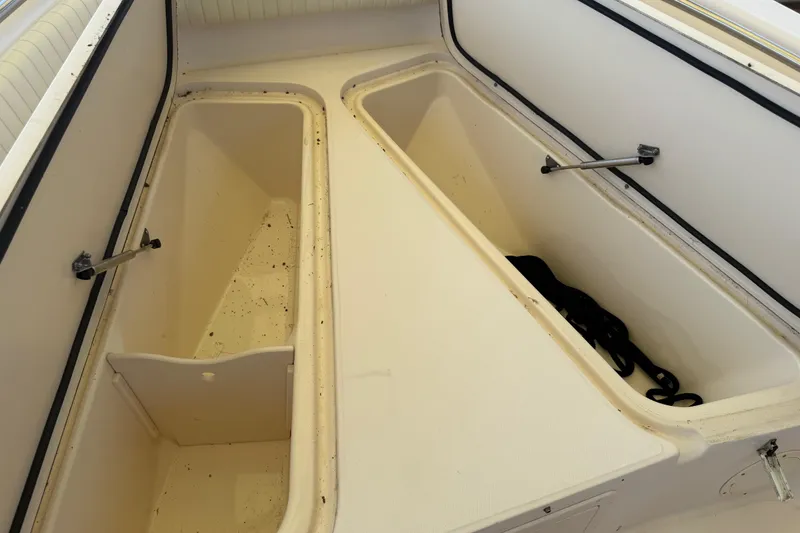 Slide: The Image of 2004 Grady-White Advance 257 boat storage compartments, open and empty, showcasing interior space. - 26