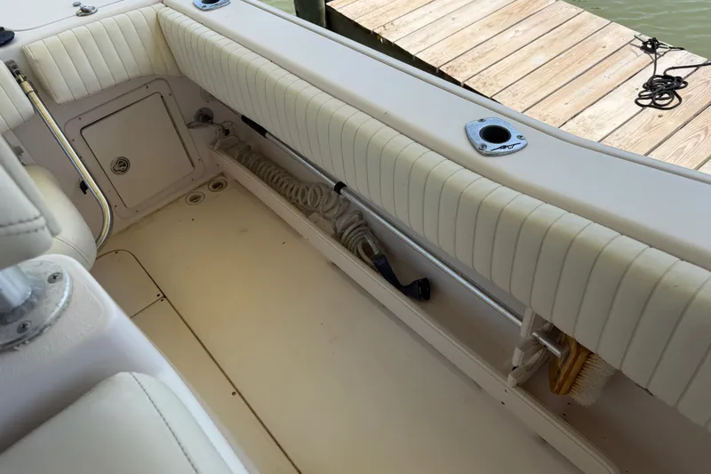 Slide: The Image of 2004 Grady-White Advance 257 boat interior with cushioned seating and storage compartment. - 28