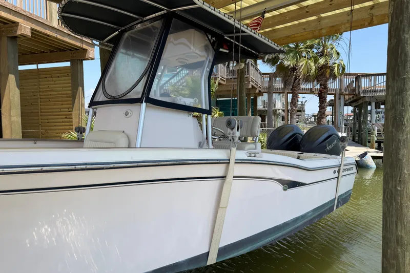Slide: The Image of 2004 Grady-White Advance 257 boat docked under wooden shelter with twin Yamaha engines. - 3