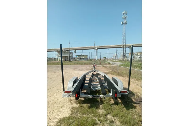 Slide: The Image of Boat trailer for 2004 Grady-White Advance 257, parked on dirt near industrial area. - 36