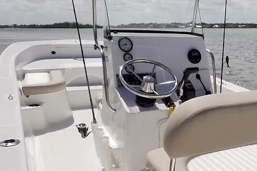 Slide: The Image of Manufacturer Provided Image: Interior view of 2025 Sundance DX20 boat, featuring steering wheel and seating on open water. - 10