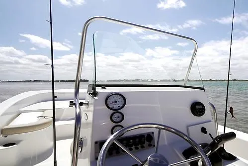 Slide: The Image of Manufacturer Provided Image: 2025 Sundance DX20 boat dashboard with steering wheel, gauges, and clear sky background. - 11