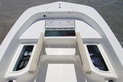 Slide: The Image of Manufacturer Provided Image: Bow view of 2025 Sundance DX20 boat with open storage compartments. - 6