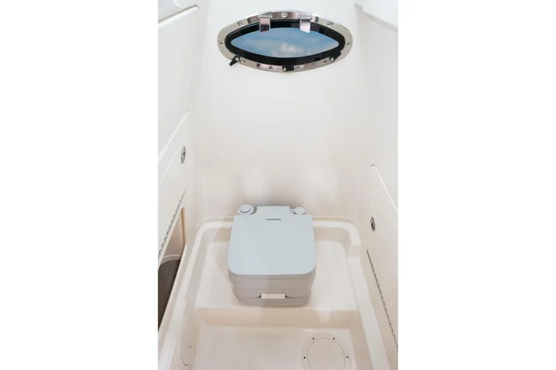 Slide: The Image of 2026 Grady-White Fisherman 236 boat interior with portable toilet and porthole window. - 12