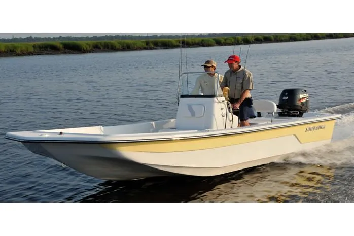 Slide: The Image of Manufacturer Provided Image: 2025 Sundance B20CCR boat cruising on a calm river with two passengers. - 2