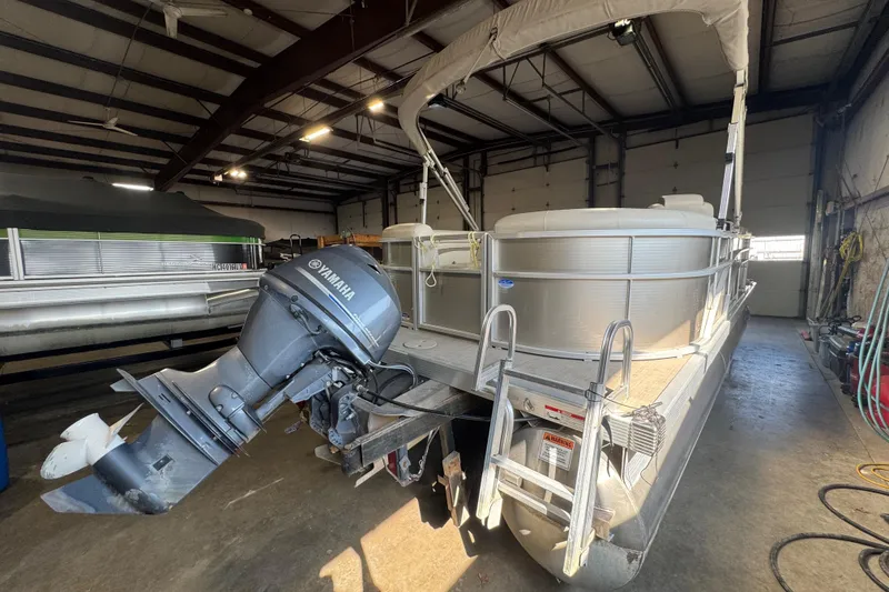 Slide: The Image of 2016 Bennington 20 SSRX pontoon boat with Yamaha motor in a storage facility. - 13