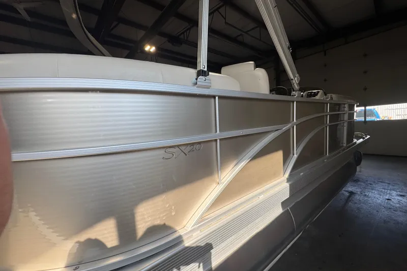 Slide: The Image of 2016 Bennington 20 SSRX pontoon boat in a dimly lit indoor setting. - 14