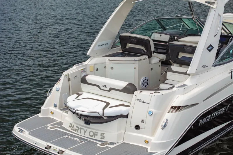 Slide: The Image of 2014 Monterey 320 Sport Yacht on water, featuring spacious deck and seating. - 10