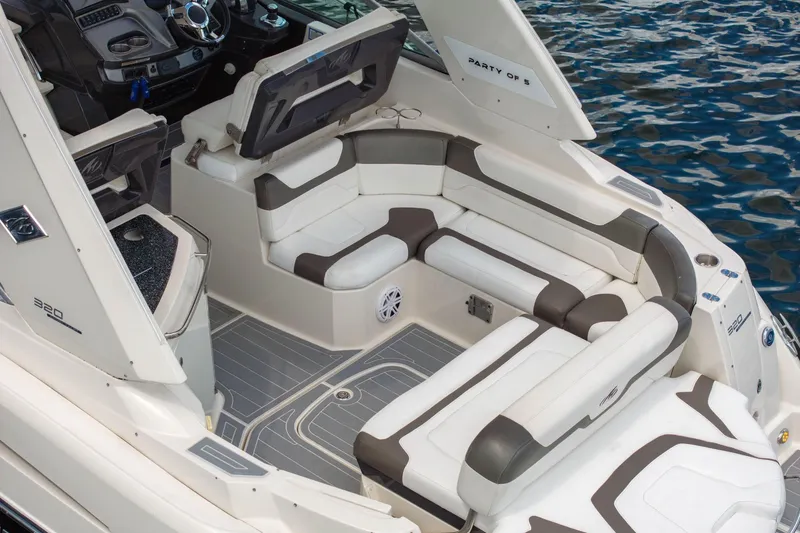 Slide: The Image of 2014 Monterey 320 Sport Yacht interior with plush seating and modern dashboard on water. - 11