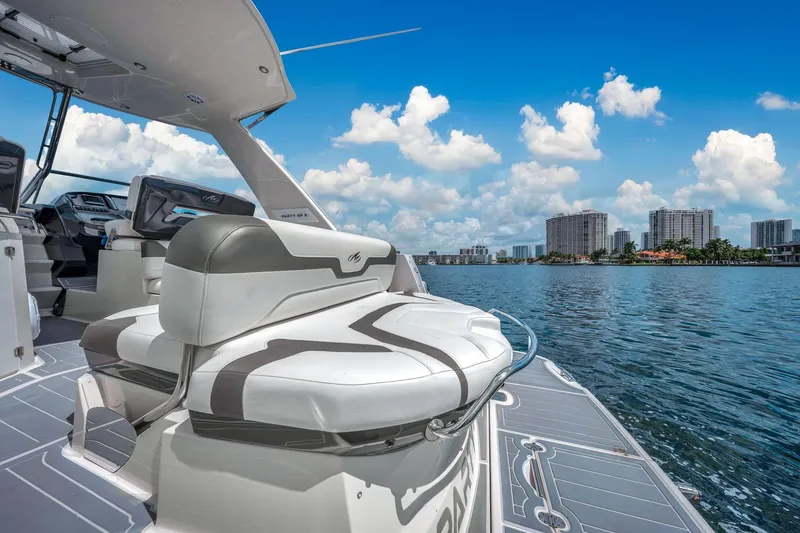 Slide: The Image of 2014 Monterey 320 Sport Yacht on water, city skyline in background, clear blue sky. - 12