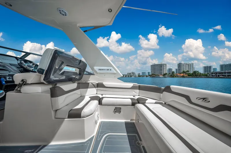 Slide: The Image of 2014 Monterey 320 Sport Yacht interior with luxurious seating, overlooking a scenic waterfront skyline. - 14