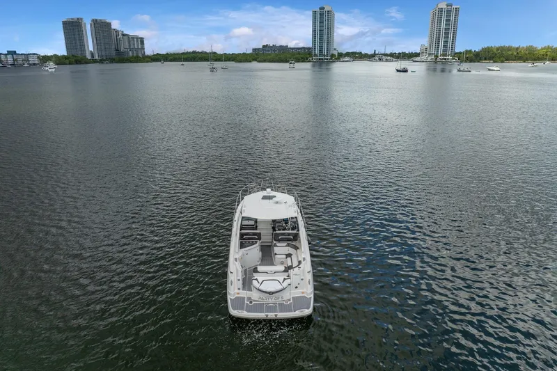 Slide: The Image of 2014 Monterey 320 Sport Yacht on calm water with city skyline backdrop. - 5